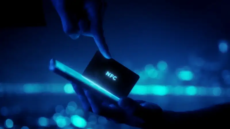 Mano acercando una tarjeta NFC a un teléfono